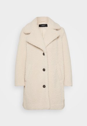 Crème-kleurige jas in een fluffy textuur met een grote kraag, twee zijzakken en donkere knopen aan de voorkant. Zacht, warm ontwerp.