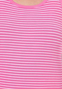 Canotta a righe rosa con sottili strisce bianche. Il tessuto è a coste, creando un aspetto testurizzato, con un collo a giro.