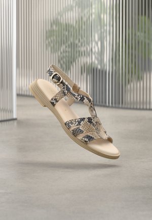 Σανδάλια με λουράκια σε μπεζ και σχέδιο φιδιού. Επίπεδη σόλα με υφή και ρυθμιζόμενο κουμπί. Ελαφρύ σχέδιο.