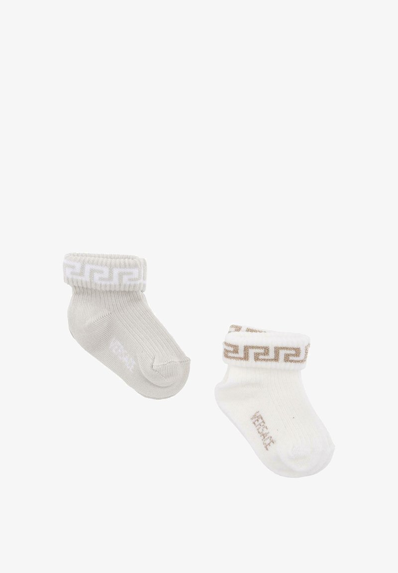 Scarpine per neonati grigie e bianche, con una texture a coste. I polsini mostrano un motivo geometrico dorato. Ogni calzino è cucito con il nome del marchio.