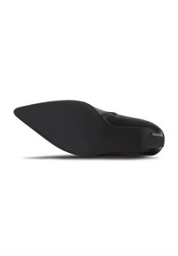 Zapato de cuero negro con punta afilada y superficie lisa. La suela es plana con un patrón texturizado para ofrecer agarre.