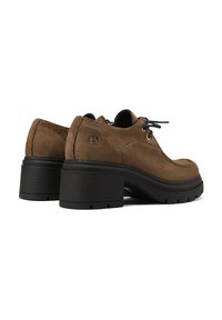 Scarpe con tacco in suede marrone, con suola in gomma nera spessa, punta arrotondata e lacci. Il lato presenta il logo del marchio. Parte superiore testurizzata e suola a contrasto.