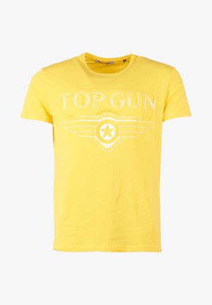 Żółta bawełniana koszulka z okrągłym dekoltem i krótkimi rękawami, z białym nadrukiem "TOP GUN" z detalem skrzydeł i gwiazdy. Miękka tekstura.