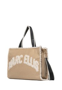 Beige draagtas met pluizig wit logo "MARC ELLIS." Voorzien van dubbele zwarte hengsels, een gestructureerde afwerking en ritssluiting. Strakke lijnen en een minimalistisch ontwerp.