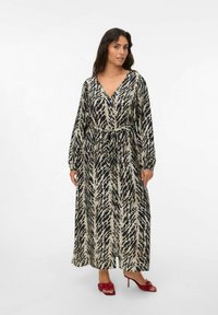 Robe longue à col en V beige avec un motif abstrait noir. Manches longues, taille cintrée avec lien, présentant une silhouette fluide et un tissu doux.