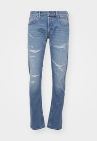 Ljust blå denimjeans med smal passform, med slitna detaljer och blekningar. Fem fickor och en klassisk knäppning.