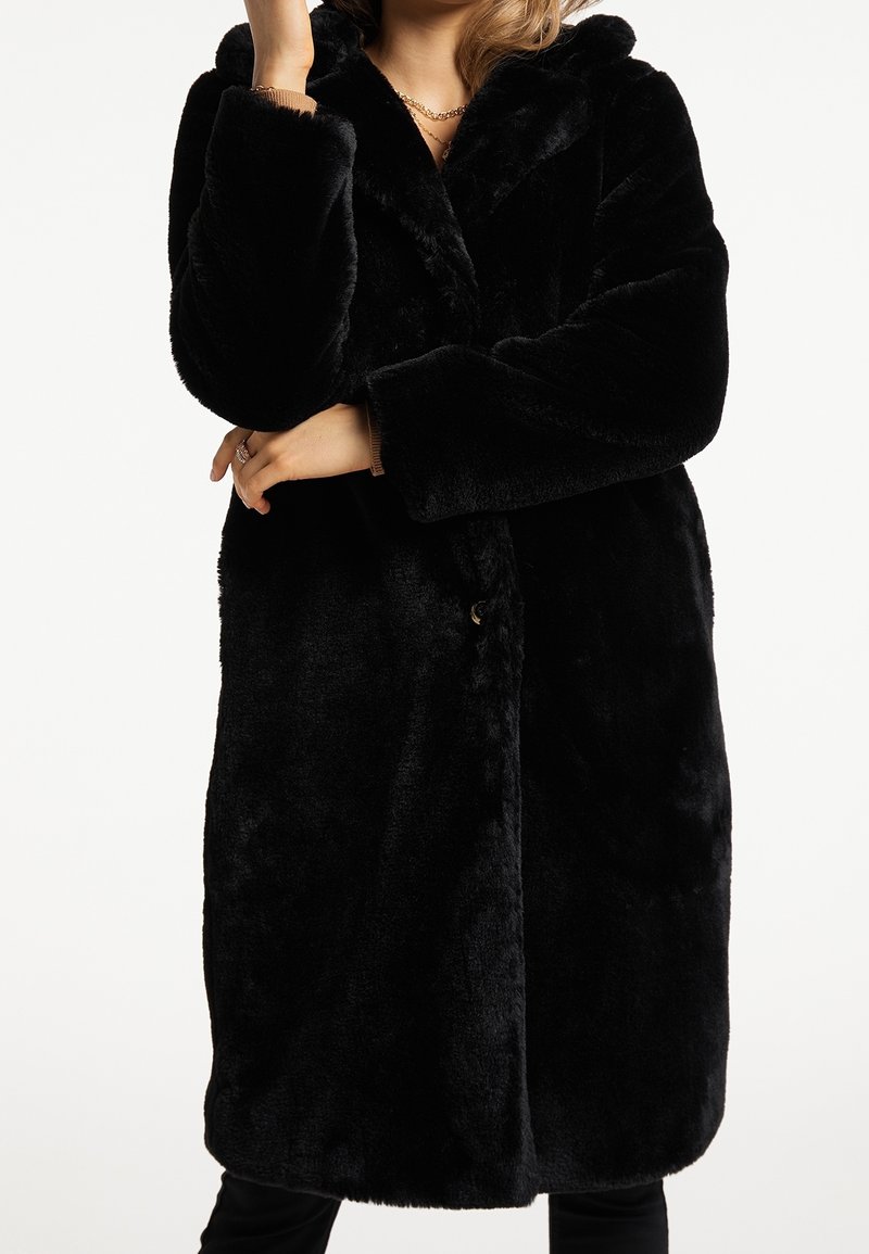 Abrigo de piel sintética negra con un solo botón, grandes solapas y mangas largas, que presenta una superficie suave y texturizada y un ajuste cómodo.