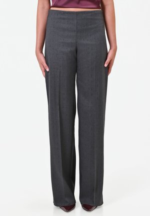 Pantalon droit gris foncé porté avec des chaussures pointues bordeaux et un top court bordeaux, montré de la taille aux pieds.