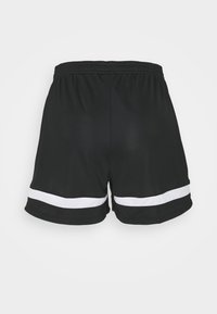 Svart sportshorts med en vit meshrand längs fållen. Tyget är lätt och har ett elastiskt midjeband för komfort.
