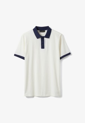 Polo bianca a maniche corte con colletto blu navy, patta con bottoni e polsini sulle maniche, stesa su uno sfondo bianco.