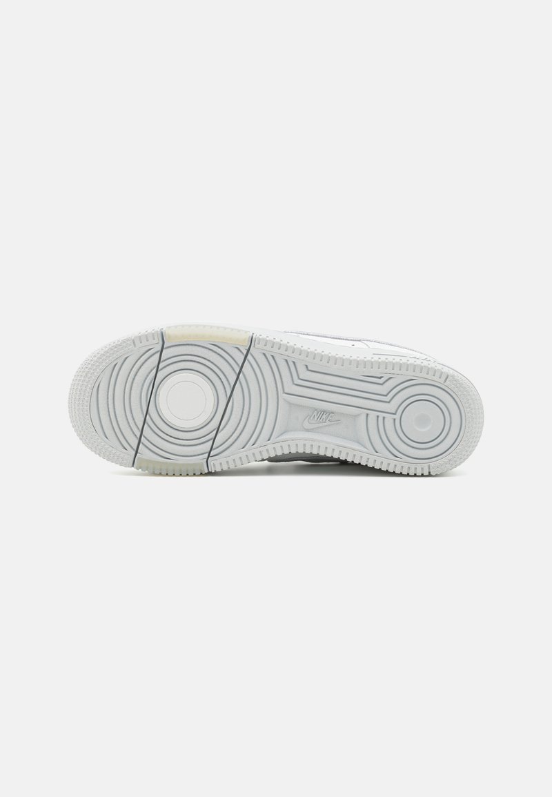 Nike-Sneaker mit einem kreisförmigen Profil auf einer weißen Gummisohle, mit strukturierten Details und einem hellgrauen Akzent.