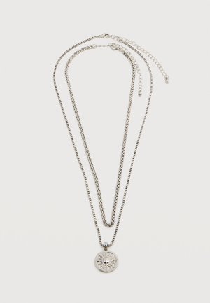 Kaks kiivrilihvitud hõbedatoonilist kaelaehet, üks ümmarguse päiksemustriga ripatsiga, mõlemal reguleeritava pikkusega kett sulgumisega valgel taustal.