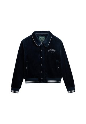 Marineblauwe fluwelen jas met witte bies en geborduurd "Superdry" logo. Voorzien van drukknoopsluiting, geribbelde mouwen en een tailleband.