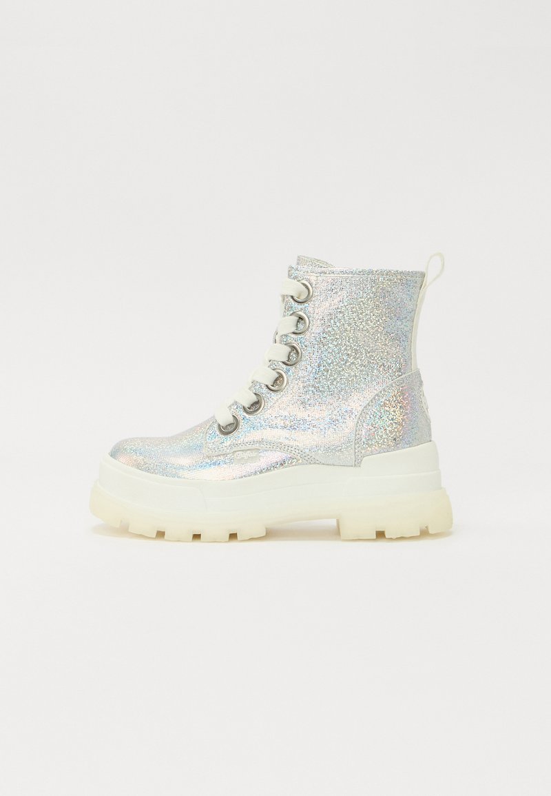 Botas de tobillo plateadas con brillos y suela blanca gruesa, con cordones redondos y una lengüeta en la parte posterior. Textura de superficie lisa y reflectante.