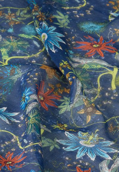 Μπλε ύφασμα με μεγάλα πολύχρωμα ανθίσματα σε κόκκινο, μπλε, πράσινο και κίτρινο, με σχέδια φύλλων και κληματαριάς, εμφανιζόμενο με πτυχώσεις και υφή.