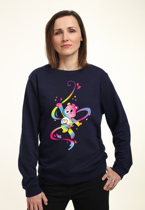 Mørkeblå sweatshirt med et farverigt tegneserie-bjørn design, der inkluderer regnbueswirls og hjerter, lavet af blødt bomuldsmateriale.
