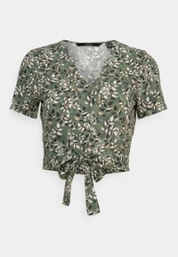 Top corto floreale verde con scollo a V, maniche corte e dettaglio con fiocco davanti. Il tessuto presenta un motivo di foglie in crema e beige.