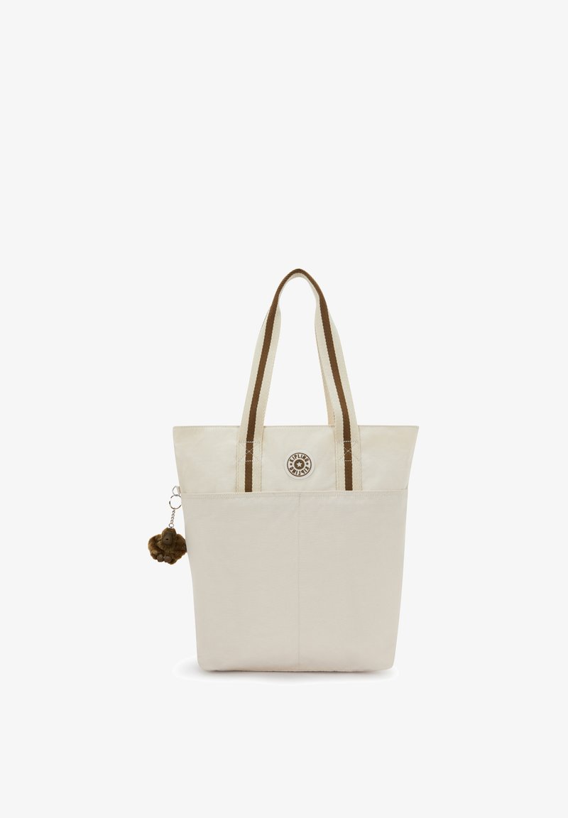 Beige indkøbsnet med brune, stribede håndtag, forlomme, rundt logo og en lille brun, pelsagtig abe-nøglering fastgjort på venstre side.