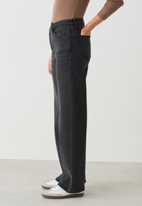 Hoge taille, rechte broekspijpen in donkergrijs denim, met een klassiek vijf-pocket ontwerp en een knoopsluiting.