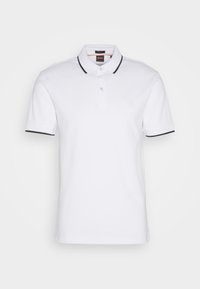 Polo blanc à manches courtes avec bordure noire au col et aux extrémités des manches, patte à deux boutons et petite poche poitrine.