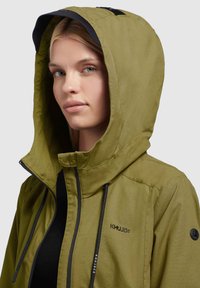 Olive green hooded jacket featuring a zip closure, black drawstrings, and logo detail. Smooth fabric with a matte texture.