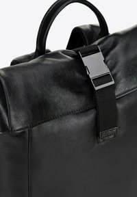 Zaino in pelle nera con superficie texturizzata, chiusura a patta con chiusura metallica e manico superiore per il trasporto.