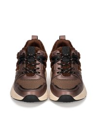 Baskets de sport marron avec un dessus en tissu texturé, des panneaux en maille et des lacets noirs. Elles sont dotées d'une semelle rembourrée et d'une semelle extérieure beige contrastante.