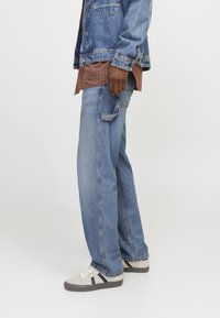 Denimjeans med en løs pasform, lyseblå farve og lige ben-design. Funktioner inkluderer synlig søm og en lille baglomme.