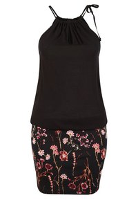 Top negro sin mangas con escote fruncido; combinado con una falda negra ajustada que presenta coloridos patrones florales en rosa, rojo y verde.