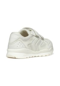 Zapatilla blanca con parte superior sintética, paneles texturizados, correa de Velcro y perforaciones para transpirabilidad. Suela de goma con patrón de dibujo ligero.