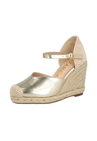 Zapato cuña metálico dorado con punta redonda, tobillo tejido en color beige y correa. Detalle de cuerda de yute a lo largo de la cuña y un acabado suave y brillante.