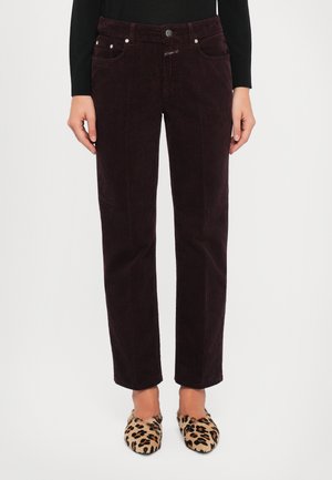 Burgundy corduroy trousers with straight legs, five pockets, and metal button closure, paired with leopard print slip-on shoes.