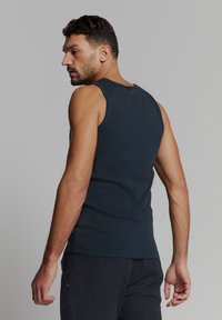 Navyblauw mouwloos tanktop van katoen, met een aansluitend ontwerp, een ronde halslijn en minimale naden. Achteraanzicht zichtbaar.