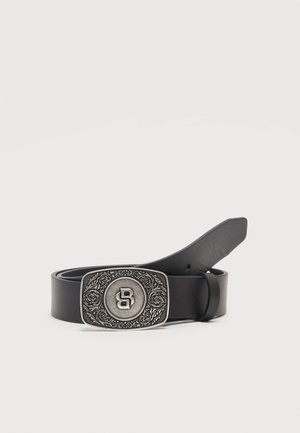 Zwarte leren riem met een rechthoekige zilveren gesp, voorzien van gegraveerde bloemmotieven en een centraal gestileerd "B"-logo.