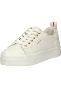 Sneaker bianco in pelle con suola in gomma testurizzata, occhielli dorati e accenti rosa chiaro, dotato di una linguetta rossa e bianca sul tallone.