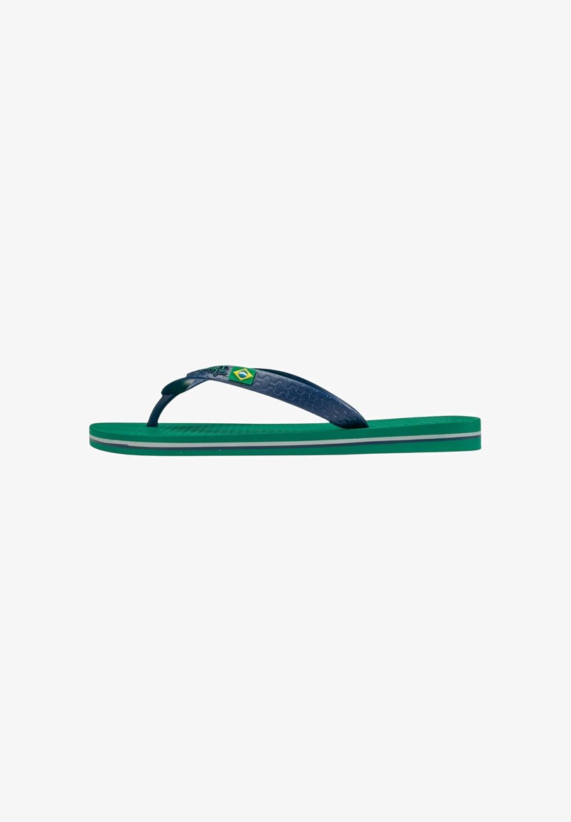 Chanclas en verde y azul marino, con una tira texturizada y un acento de bandera. La suela tiene un diseño de varias capas con rayas contrastantes.