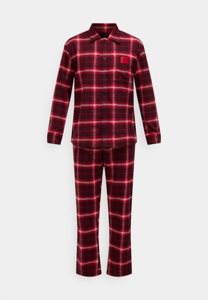 Punamusta ruudullinen flanellipyjama, jossa on pitkähihainen paita ja housut; paidassa on napillinen kaulus ja rintataskussa logo.