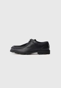 Schwarze Lederschuhe mit runder Zehenform, ausgestattet mit einer Schnürung und einer strukturierten Gummisohle. Der Stil umfasst dekorative Nähte.