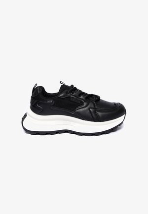 Mustad mustad jalanõud nahast ja võrgust ülemise osaga, millel on paks valge vahepôhi ja tekstureeritud must välispind. Sisaldab paeltesüsteemi ja kanna sildi.