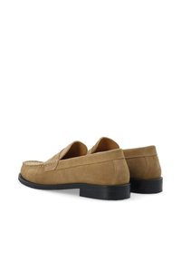 Tanfarbene Wildleder Slipper mit niedrigem schwarzen Absatz, zierende Stiche und einem leichter Slip-On-Design. Glatte Textur und abgerundete Zehenform.