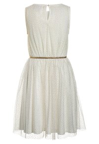 Robe blanche sans manches avec des pois dorés, ceinture dorée cintrée, dos en trou de serrure avec un bouton, et jupe en tulle superposée.