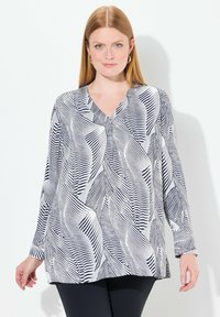 Top a maniche lunghe con un motivo astratto a foglia bianca e blu navy, dotato di scollatura a V e vestibilità rilassata. Tessuto morbido e leggero.