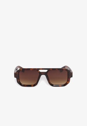 Lunettes de soleil rectangulaires écaille avec verres dégradés marron et une petite découpe au-dessus du pont sur fond blanc.
