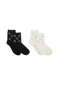 Calzini in cotone nero e crema con un design a coste, caratterizzati da piccoli disegni a linee di volti in un motivo ripetuto sulla superficie.