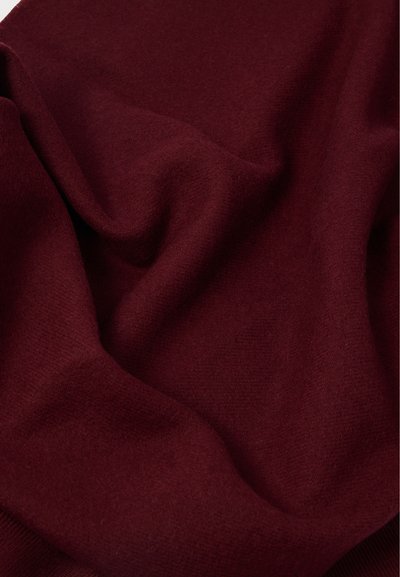 Βουργουνδικό ύφασμα με λεία, απαλή υφή, που παρουσιάζει διακριτές πτυχές και τσακίσματα, υποδηλώνοντας ελαφρύ υλικό. Δεν είναι ορατά σχέδια ή αξεσουάρ.