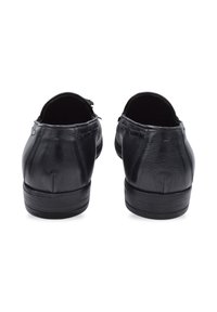 Czarne skórzane buty o gładkiej fakturze, zaokrąglonym tylnym panelu, niskim obcasie i minimalnych detalach przeszycia wzdłuż górnej krawędzi.