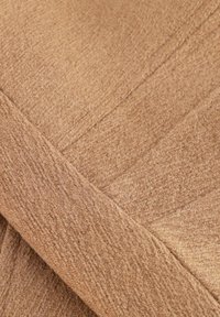 Beige stof met een zachte, gestructureerde oppervlakte. Heeft een diagonaal weefpatroon en gladde, afgewerkte randen, die een gelaagd ontwerp creëren.