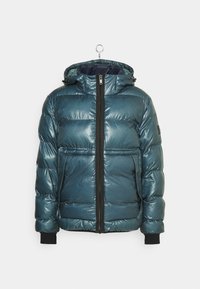 Teal pufferjacka med en blanka yta, dragkedjestängning, justerbar huva och svarta ribbade ärmmuddar. Boxig form med vertikal quiltad design.