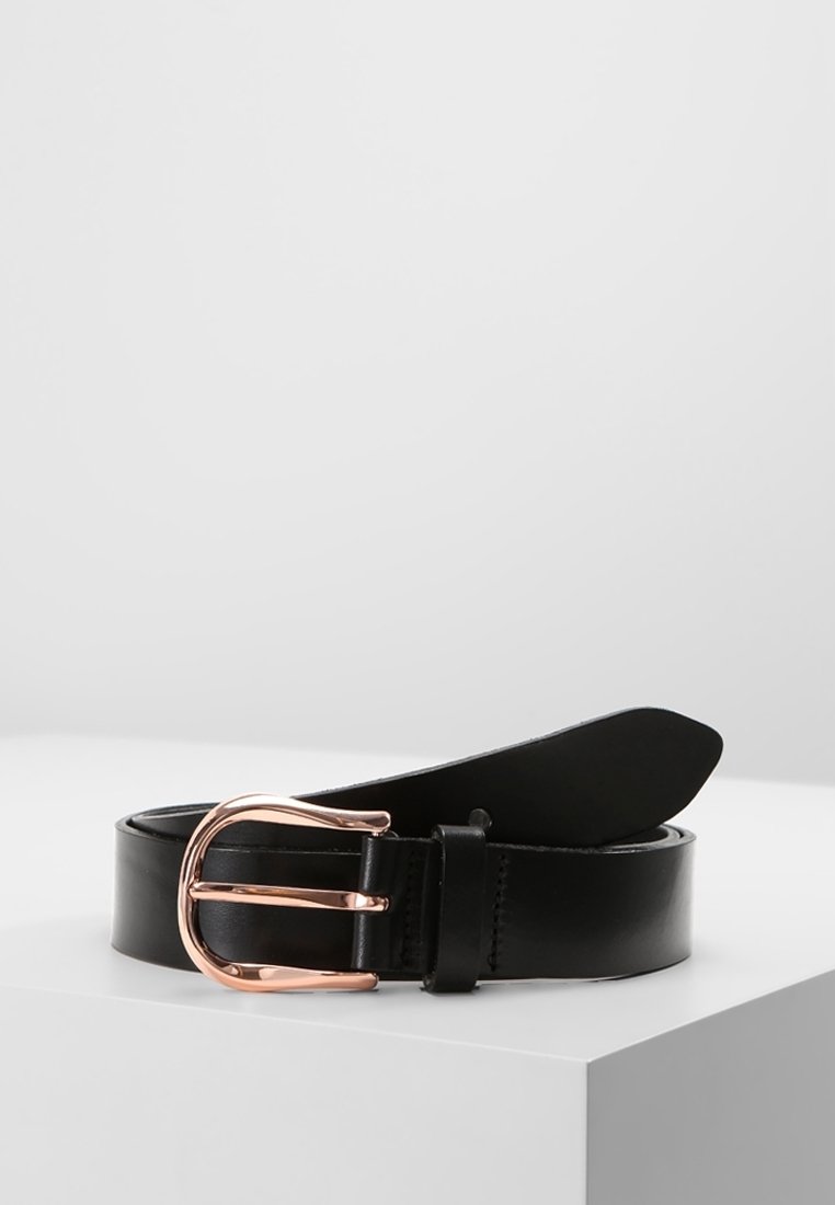 Ceinture en cuir noir enroulée sur une surface blanche avec une boucle métallique arrondie en or rose brillant.