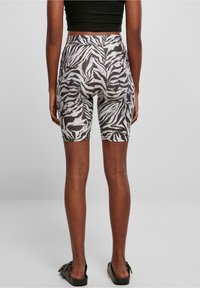 Hoogwaardige fietsshorts met een zwart-wit zebra print, gemaakt van een rekbaar materiaal met een gladde textuur.